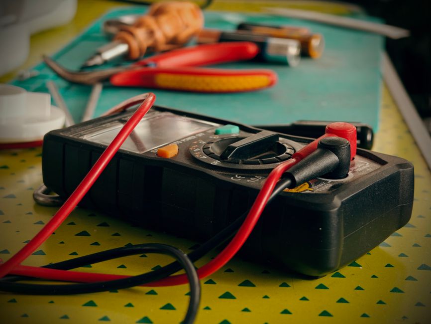 Multimètre et outils d'électricien sur un plan de travail