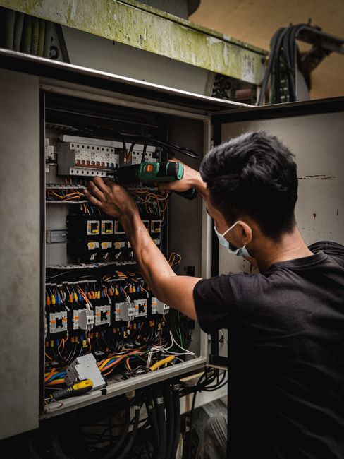 Électricien intervenant sur les disjoncteurs d'un tableau