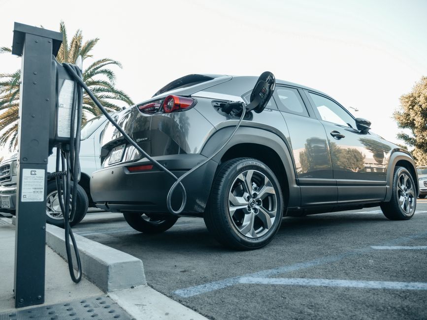 Véhicule électrique en charge sur une borne de parking